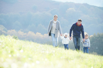 Fototapeta premium Happy family walking in countryside on autumnal week-end