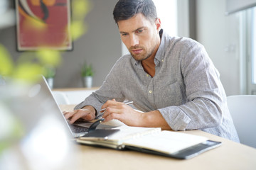 Middle-aged man working from home on laptop computer