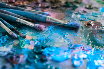artists brushes and oil paints on wooden palette