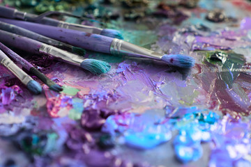 artists brushes and oil paints on wooden palette