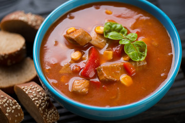 Close-up of tomato soup with tilapia fish and vegetables