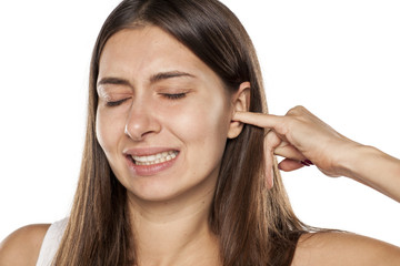 nervous young woman scratching her ear with a finger..