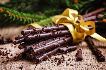 Christmas present chocolate on old wooden background with fir br