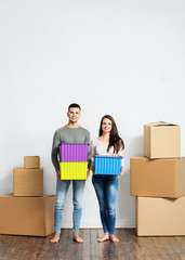 Young couple holding boxes in their new home