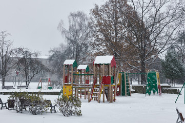 Naklejka premium Children playground in winter snow covered snowfall