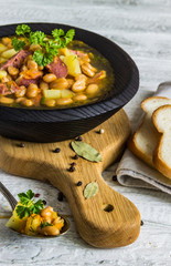 Bean, tomato, bacon and sausage stew with toasted bread