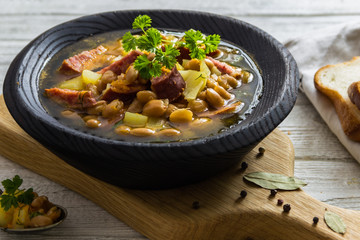 Bean, tomato, bacon and sausage stew with toasted bread