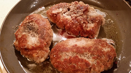Fresh appetizing meat schnitzel fried in a pan in hot oil