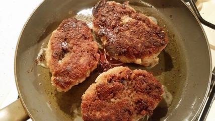 Fresh appetizing meat schnitzel fried in a pan in hot oil