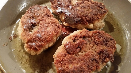 Fresh appetizing meat schnitzel fried in a pan in hot oil