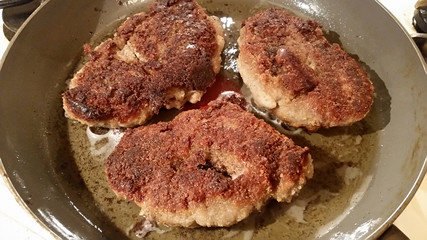 Fresh appetizing meat schnitzel fried in a pan in hot oil