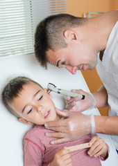 Obraz na płótnie Canvas Doctor examines child's ear