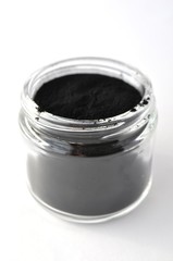 Powdered activated charcoal for facial mask in jar with copy space