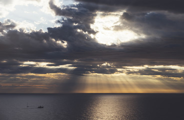 Obraz premium Clouds blue sky and sunlight sunset on horizon ocean . Сloudscape on background seascape dramatic atmosphere rays sunrise. Relax view waves sea with ship, mockup nature evening concept..
