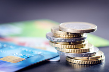 Euro money and credit cards are isolated on a dark background. Currency of Europe. Balance of money. Building from coins. 