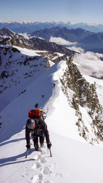 a mountain climber on the summit ridge after a climb through a steep north face in the Italian Alps