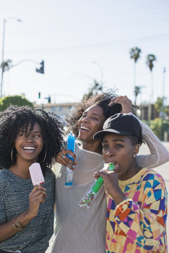 Smiling friends having popsicle outdoors