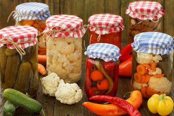 Homemade Canned Vegetables. Pickled Cucumbers, cauliflowers, carrots and peppers  In Glass Jar.
