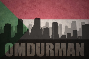 abstract silhouette of the city with text Omdurman at the vintage sudanese flag © luzitanija