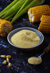 Corn grits and corncob on concrete background