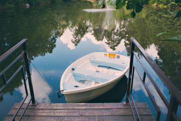 boat stand on a forest lake during the peak of summer in mountains.