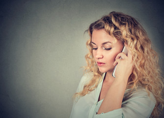 Young sad woman talking on mobile phone
