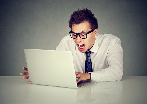 Angry business man screaming at computer