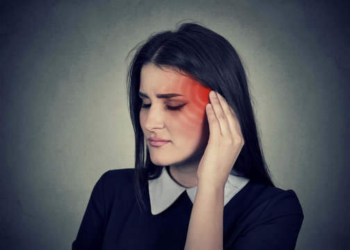 Tinnitus. Sick woman having ear pain colored in red head