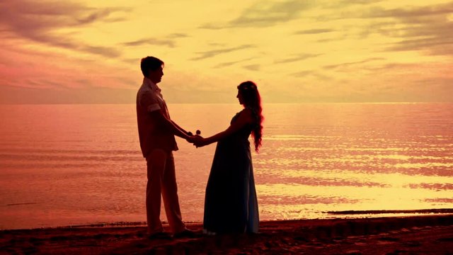 Couple beach sunset. Couple silhouette beach. Pregnant couple sunset. Love couple sunset. Silhouette couple kissing at golden sunset. Love couple kissing on sea beach at sunset. Couple sunset beach