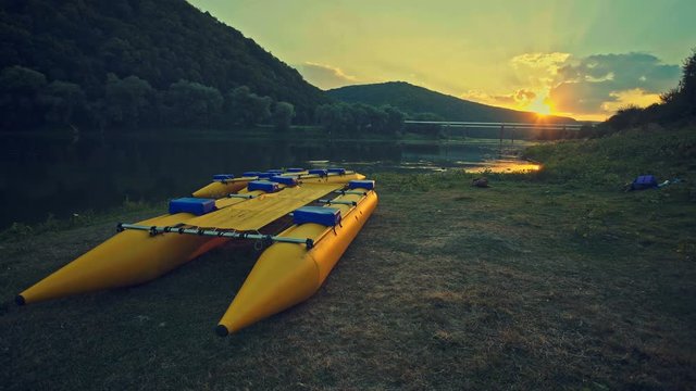 Catamaran for rafting on the river at sunset background in green mountains