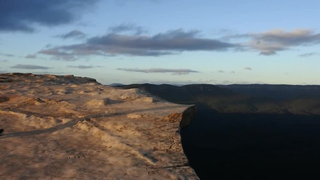 Landscape photographer stands on a cliff and photographing the landscape of the Blue Mountains, Australia 