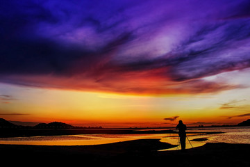 Fototapeta na wymiar Abstract sunset,Man standing to take a photo sunset,thailand