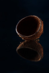 Half of coconut over black background.