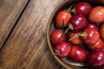 tomate de árbol - Tamarillo - Frutas exóticas del trópico sobre fondo de madera natural - toma...
