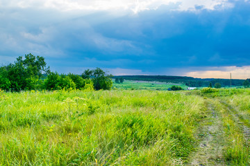 Fototapeta na wymiar Storm sky under a summer meadow at the Urals