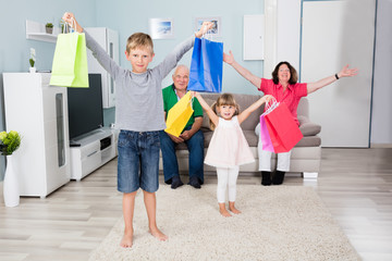 Fototapeta premium Grandchildren Holding Shopping Bag At Home
