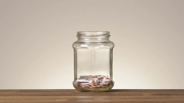 Coins In Savings Jar. Stop Motion Footage