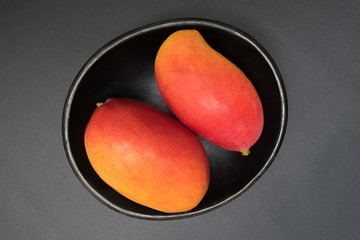 Mangos - Frutas exóticas tropicales sobre fondo negro - fotografía de estudio