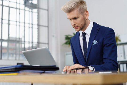 mann arbeitet am laptop im büro