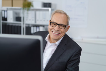 lächelnder älterer geschäftsmann im büro