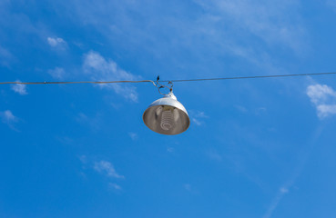 street light on wires on a background of blue sky
