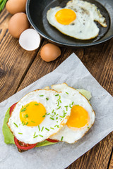 Wooden table with Fried Eggs (on a Sandwich)