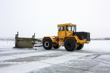 Heavy tractor cleans the runway from snow