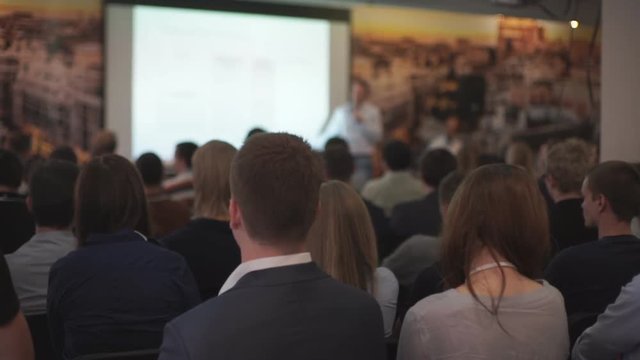 The audience listens to the acting in a conference hall