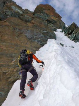a mountain climber on a steep mountain face in the Swiss Alps near Zermatt