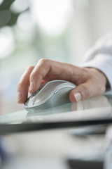 Fototapeta premium male hand clicking a cordless computer mouse on a green table