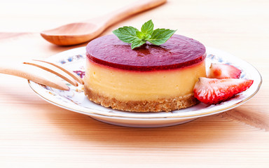 Strawberry cheesecake with fresh mint leaves on wooden backgroun