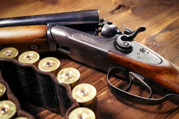 Zelfklevend Fotobehang Shotgun with shells on wooden background © zorandim75