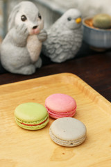 colorful macaroons on wooden plate with vintage filter