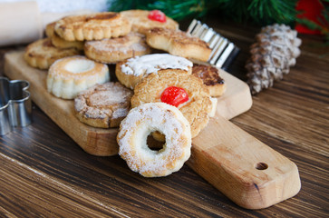 Mantecados, typical sweets consumed in Spain at Christmas. Spanish shortbread served with black coffee on wooden background with fir tree.